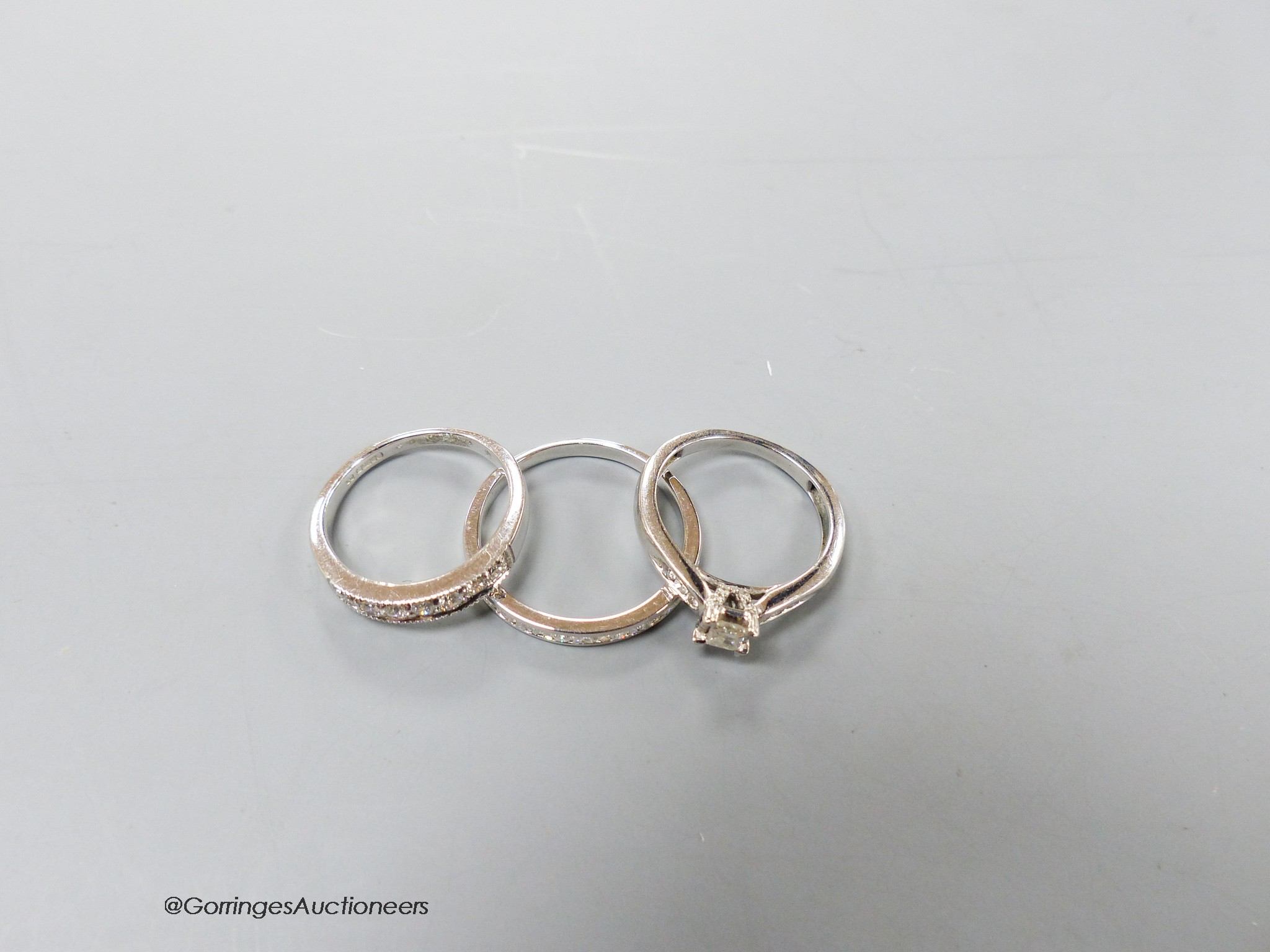 Two modern 9ct white gold and diamond set rings including a seven stone half hoop and a white metal and diamond chip set half eternity ring, gross 6.9 grams.